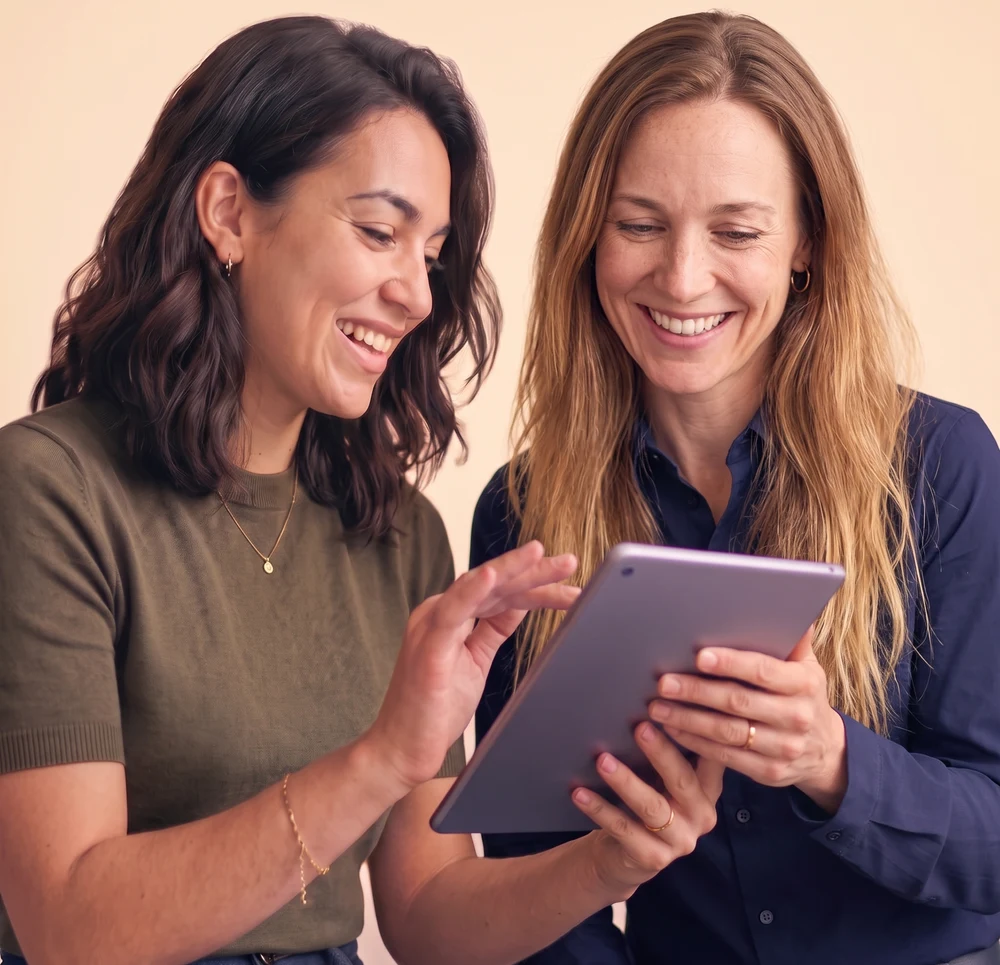 Person enthusiastically showing a time tracking report on a tablet to an engaged coworker
