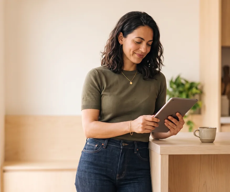 Delivery lead checking timesheet submission status on a tablet at an office counter